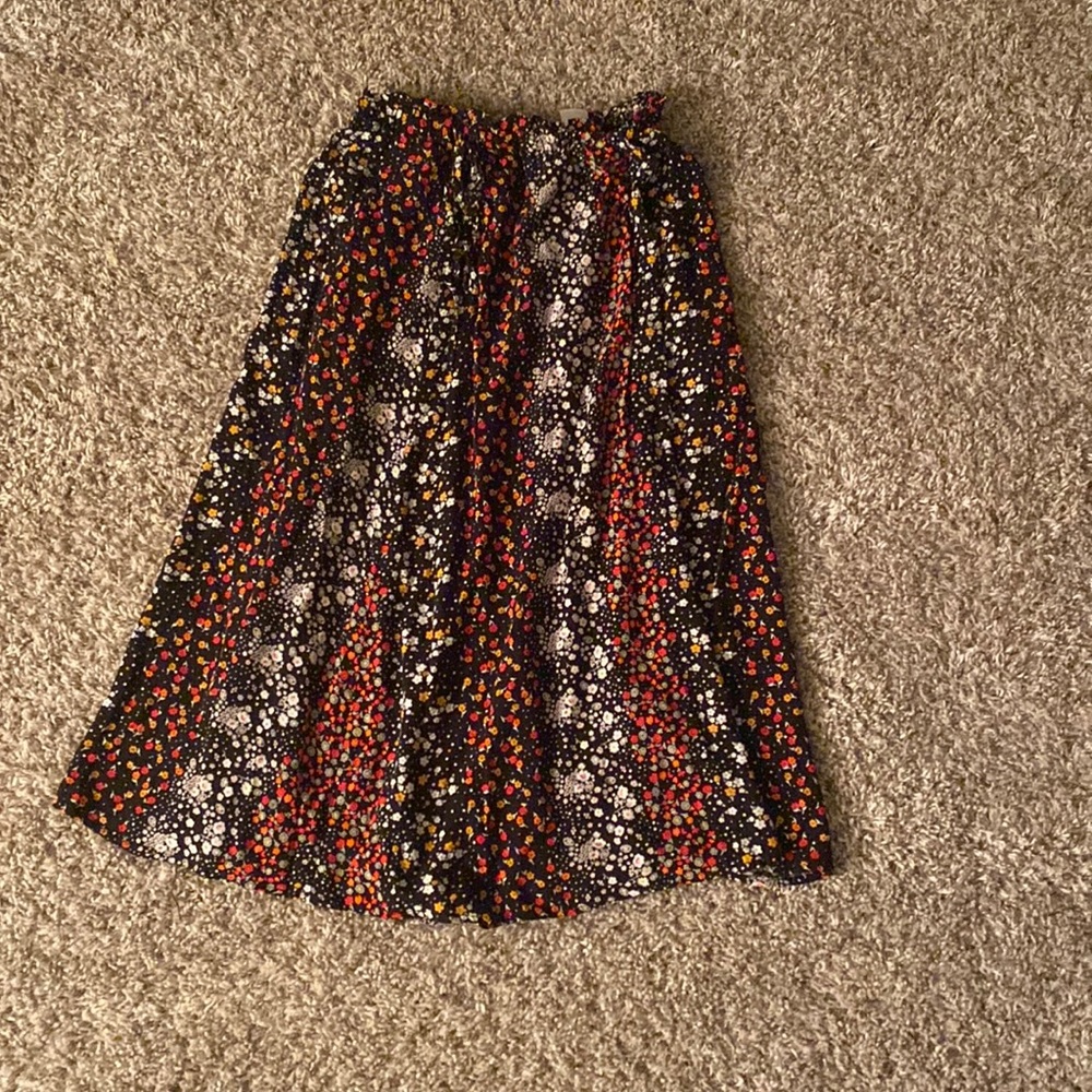 Longish skirt, white, orange, and red flowers all around the skirt.